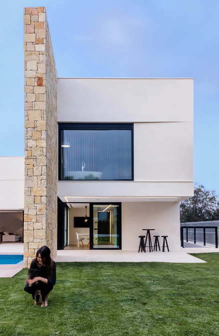 Fachada minimalista con muro de piedra en casa de diseño Cumbres