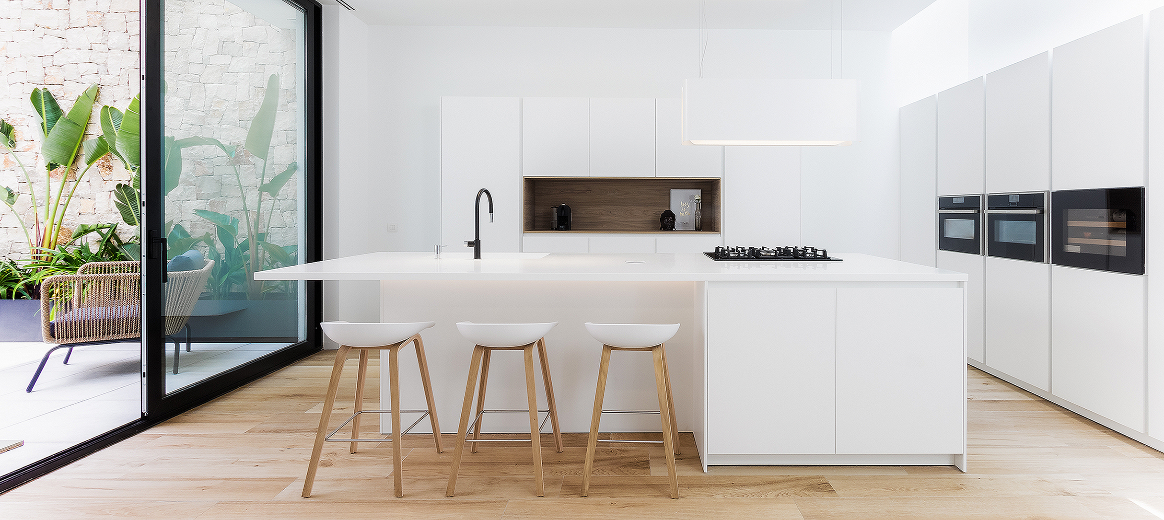 Cocina santos minimalista blanca. Suelo de madera. Patio interior