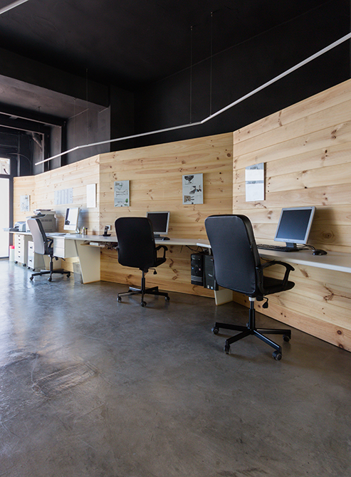 Despacho con pared moderna de madera y suelo de hormigon pulido