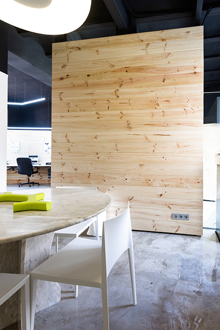 Mueble de madera separador en despacho con mesa de reuniones redonda de marmol