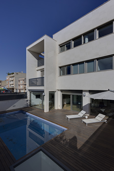 Casa moderna con piscina. Patio de madera moderno y blanco. Casa abierta a la terraza con hamacas blancas y modernas.