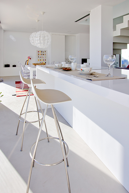 Isla de cocina central en microcemento con taburetes de Stua | Chiralt arquitectos valencia