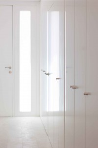Recibidor con luz natural y armario blanco minimalista low cost en reforma de casa. Chiralt Arquitectos Valencia.