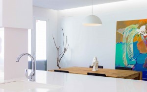 Decoración de cocina comedor estilo nórdico minimalista con mesa de madera maciza en reforma de casa. Lámpara de cocina blanca y encimera blanca de granito.Chiralt Arquitectos Valencia.