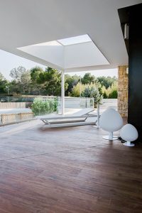 Terraza con lucernario y hamaca moderna y minimalista con suelo porcelanico imitacion madera
