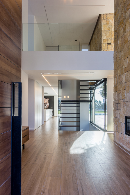 Recibidor con doble altura de piedra en casa diseño Cumbres de Chiralt Arquitectos Valencia