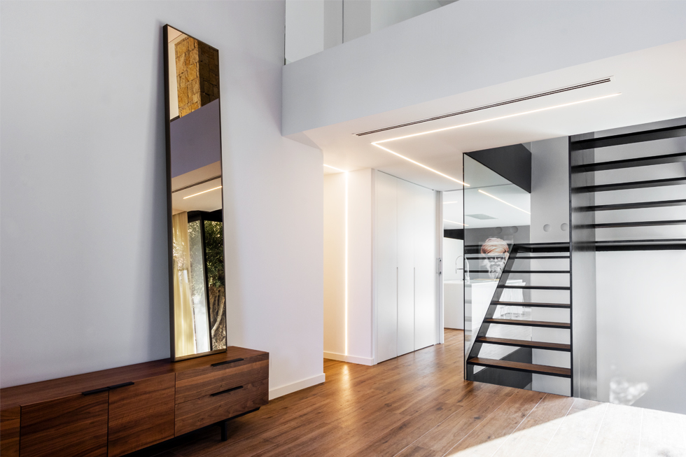 Recibidor con doble altura de piedra en casa diseño Cumbres de Chiralt Arquitectos Valencia