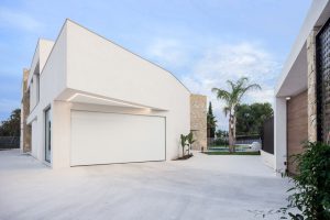 Garaje moderno con voladizo en blanco en casa de diseño Cumbres de Chiralt Arquitectos Valencia