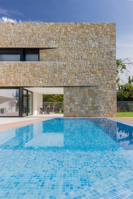 Piscina y fachada de piedra en casa de diseño Cumbres de Chiralt Arquitectos Valencia