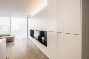 Armariada blanca con mueble de TV en vivienda estilo nórdico - Chiralt Arquitectos Valencia
