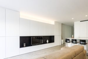 Armariada moderna blanca con mueble TV en vivienda estilo nórdico - Chiralt Arquitectos Valencia