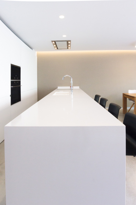 Isla de cocina blanca moderna en vivienda estilo nórdico - Chiralt Arquitectos Valencia
