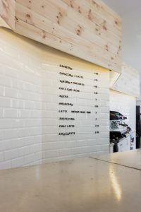 cafetería-de-diseño-en-Valencia. con mostrador de hormigon y pared de ladrillos metro y madera