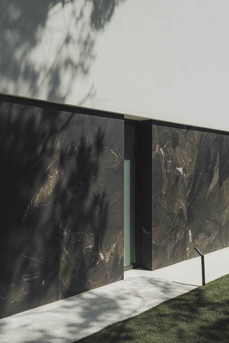 detalle de fachada con contraste blanco y negro y sombras de pinos en casa moderna en Valencia